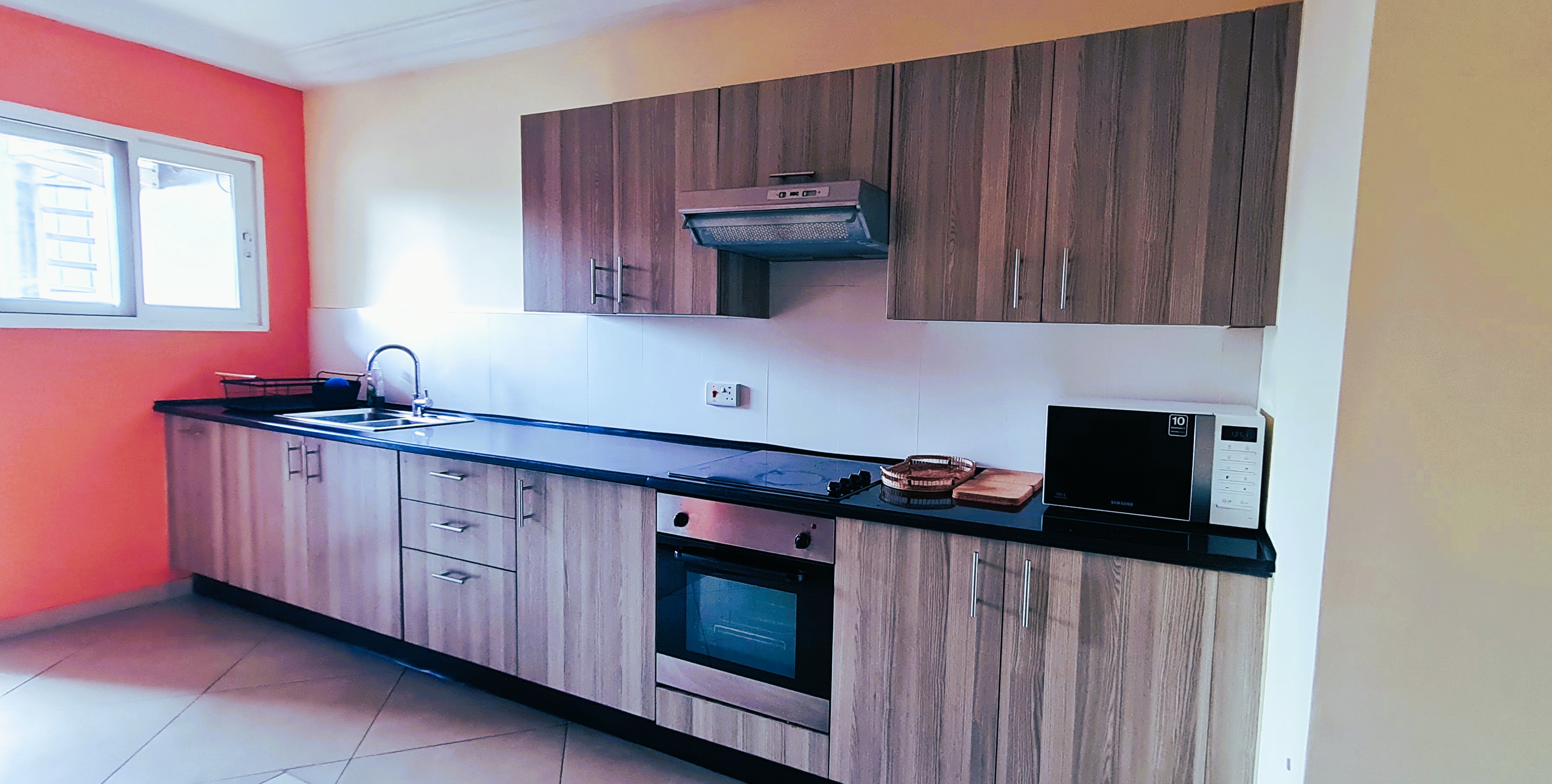 Kitchen inside the East Legon apartment with oven, hob and microwave